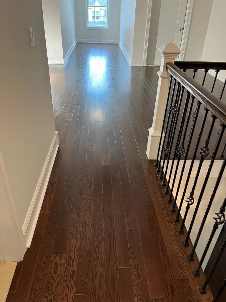 Hardwood hallway flooring with staircase railing in a Connecticut home