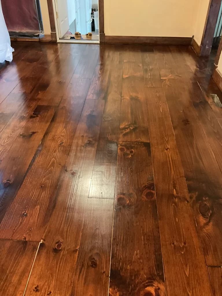 Refinished rustic pine plank flooring in a Connecticut home