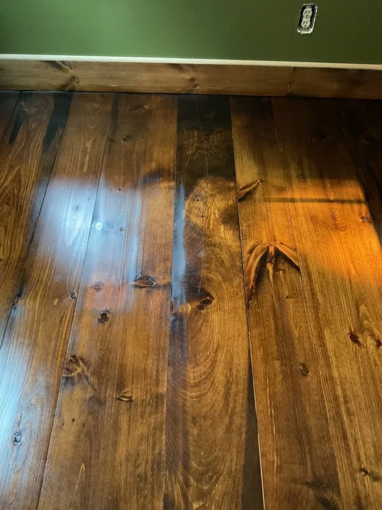 Refinished rustic pine plank flooring detail in a Connecticut home